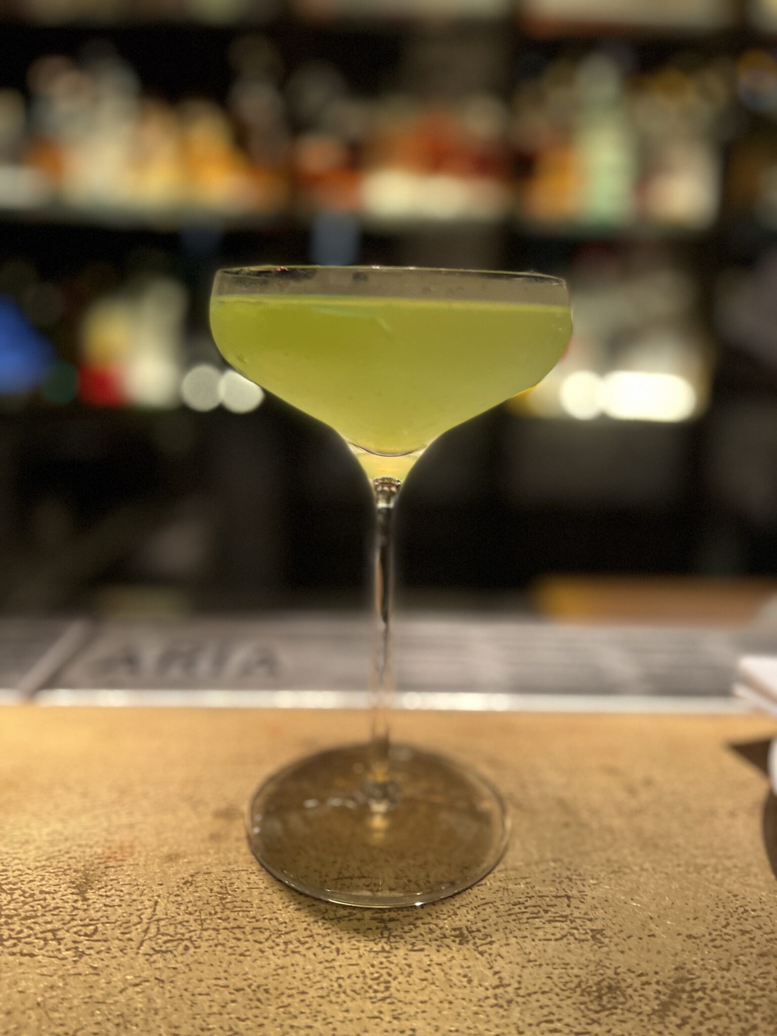 Ein schöner Drink mit gelblich grüner Farbe in einem eleganten Glas, das beschlagen ist