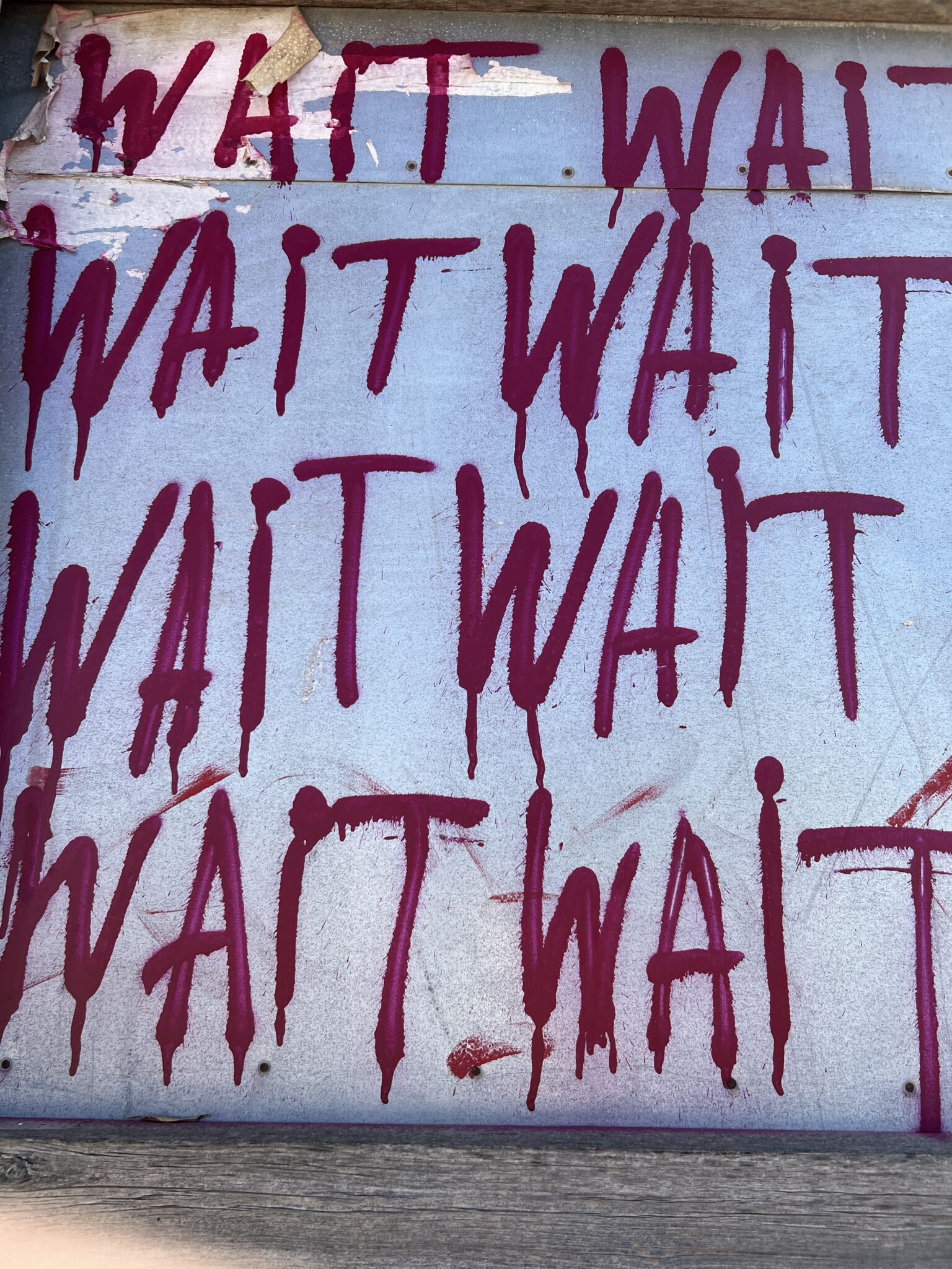 Street art in Tel Aviv, „Wait“ in roter Schrift auf weißer Wand