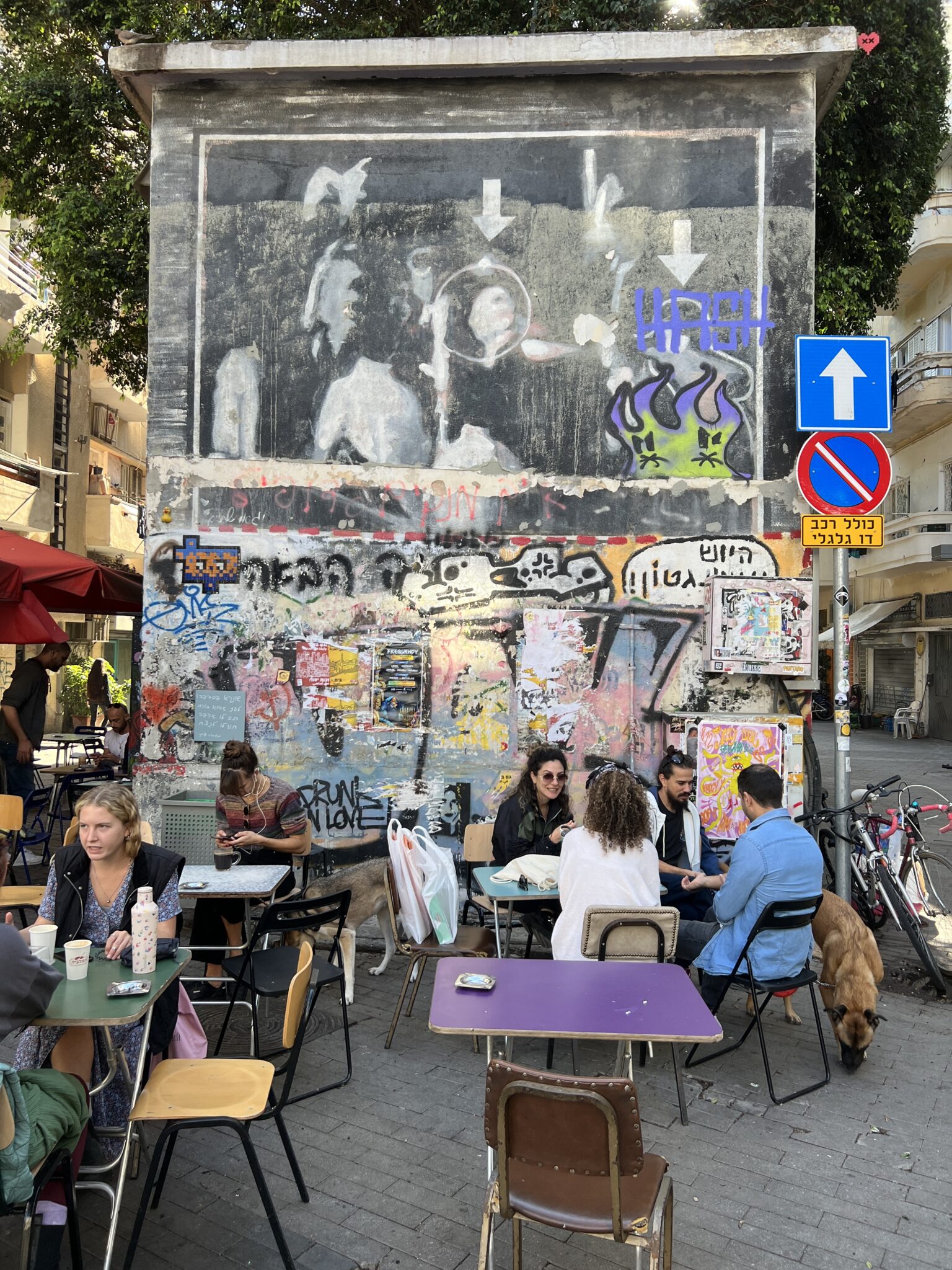 ein alternatives Straßen-Café in Florentine, junge Leute, vor einer Graffiti-Wand