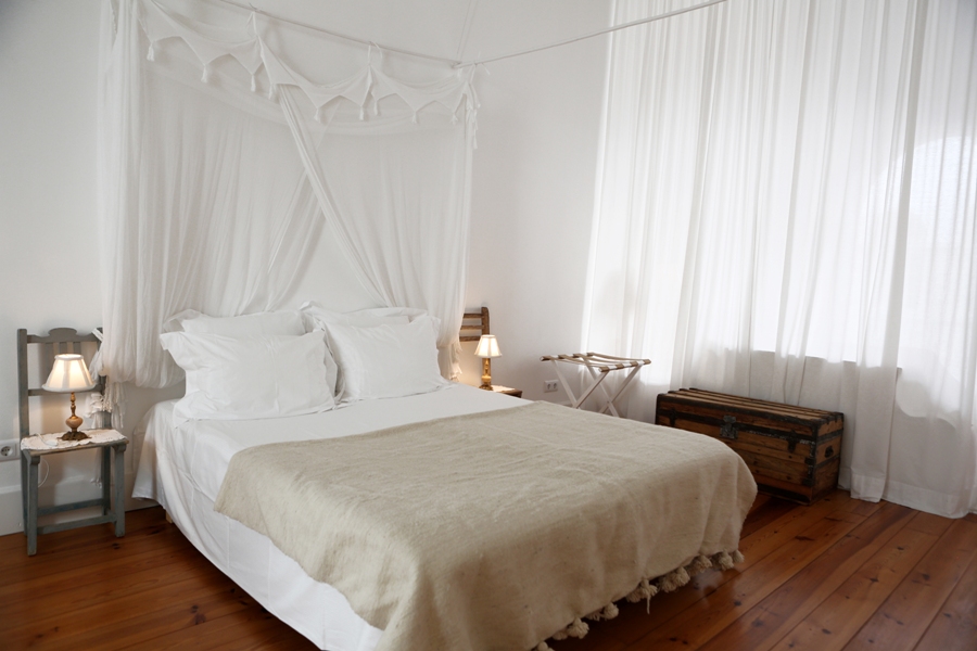 großes Bett in einem stilvollen, hellen Schlafzimmer. Bild von Local Hideaways