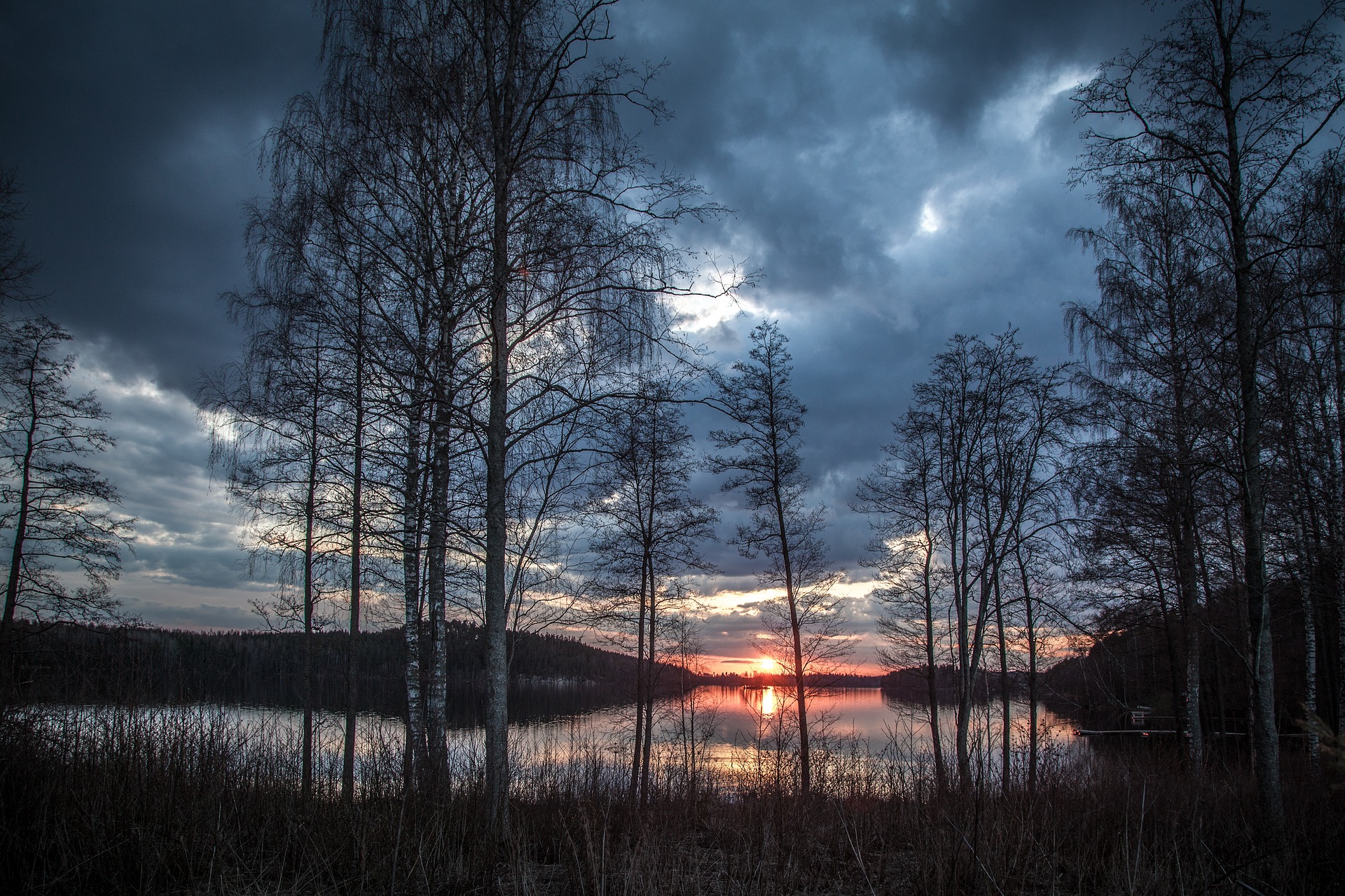 Finnland, Skandinavien, Bild von See mit Ufer, untergehende rote Sonne. Reise-Trends 2023