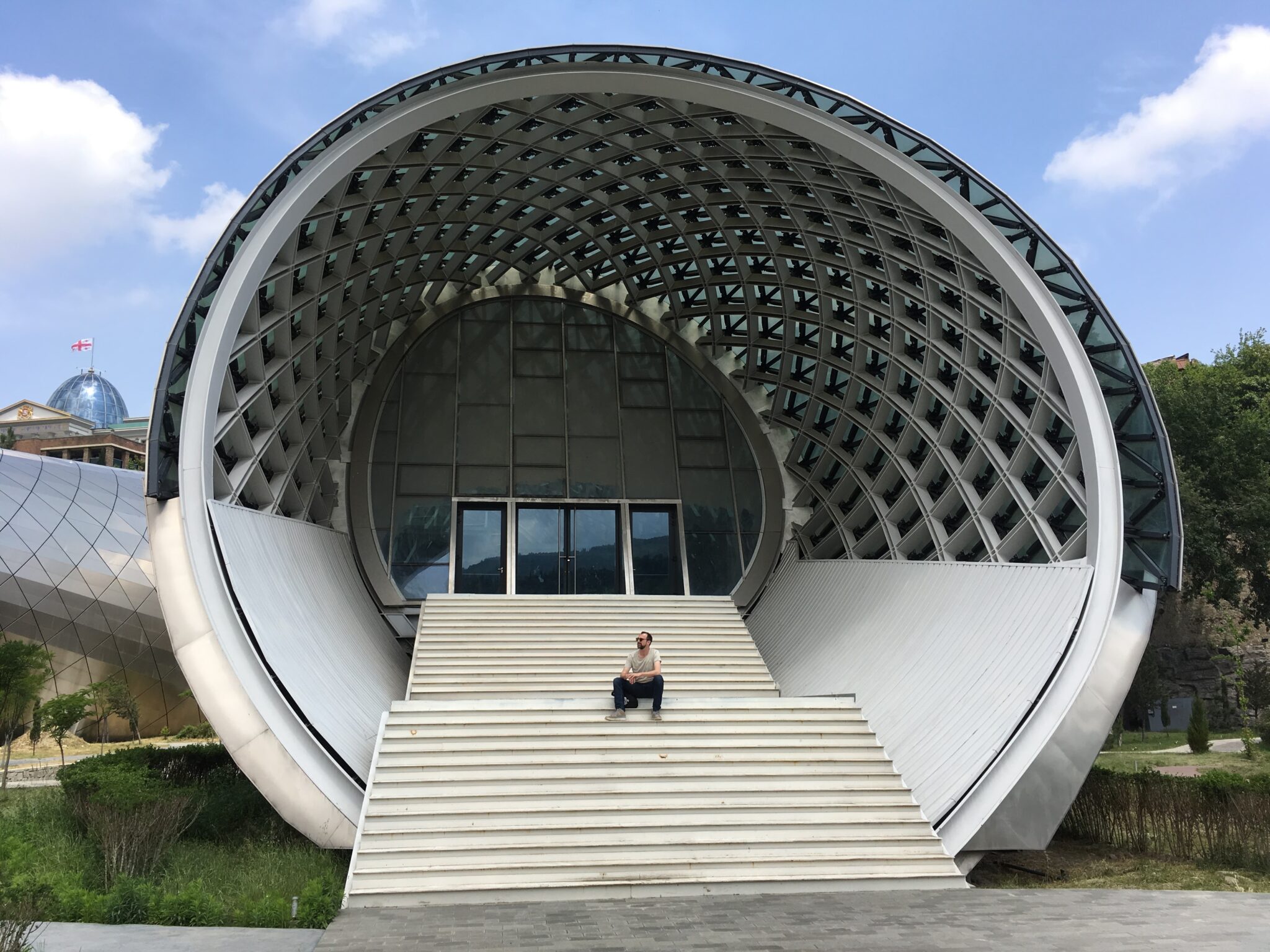 Michael sitzt auf den Treppenstufen der Konzerthalle im Rike Park