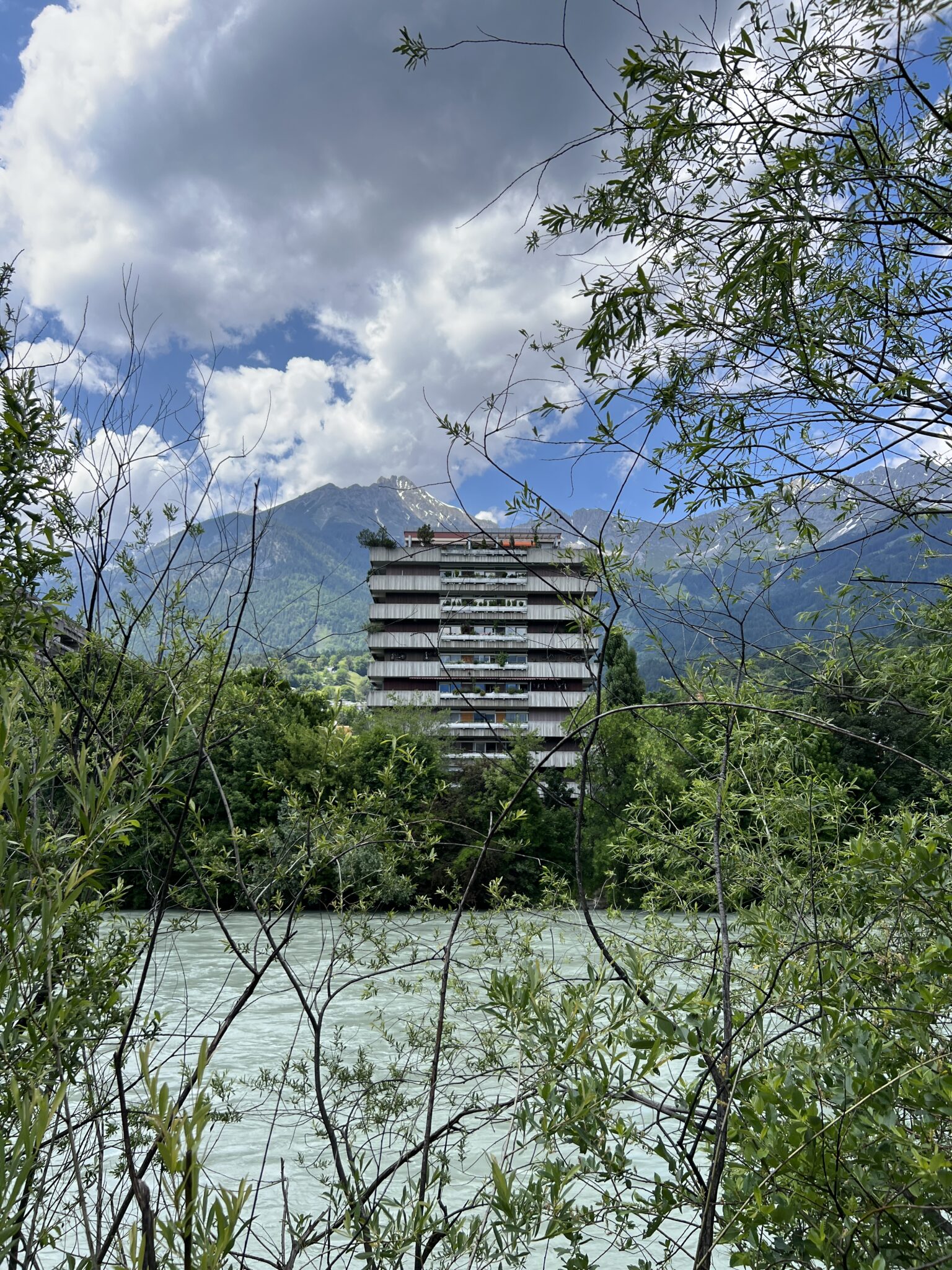 brutalistische Architektur Innsbruck vor Alpenpanorama und Fluss Inn im Bild
