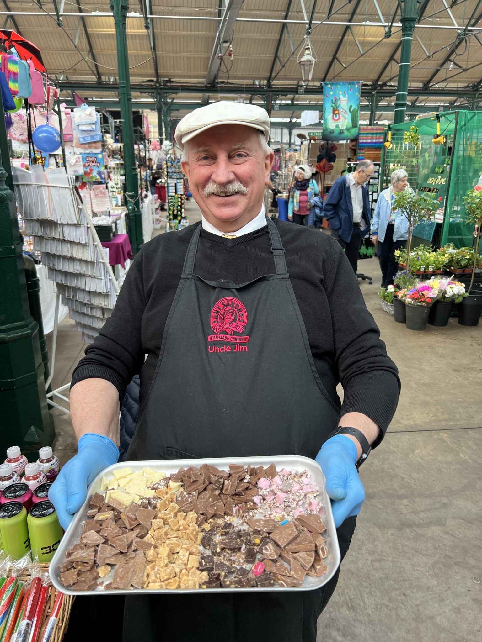 St. George's Market, Verkäufer hält lächelnd Schokokadentablett in St. George's Market